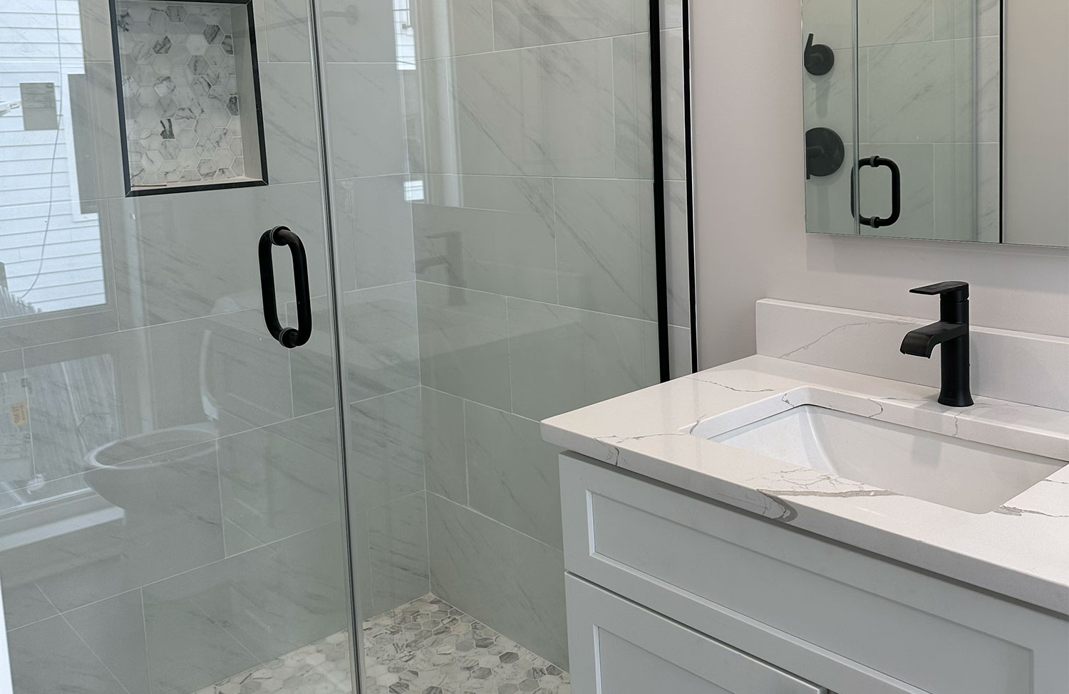 Primary bathroom renovation with glass shower and floating vanity